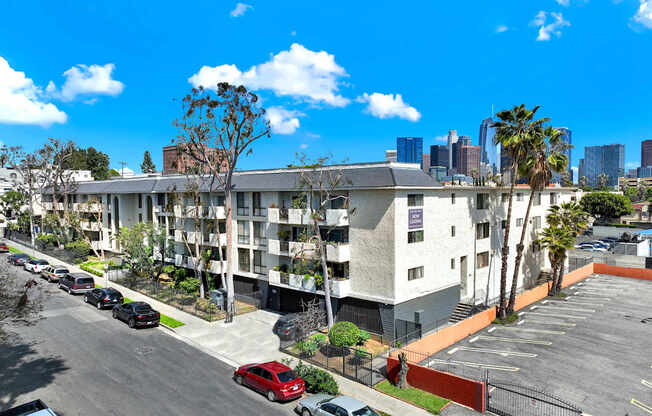 A parking lot with cars and a building in the background.