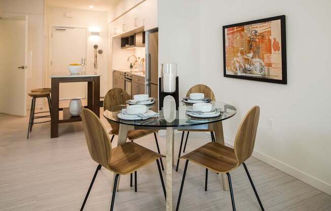 A modern dining room with a glass table and chairs.