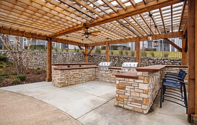 pergola with two outdoor grills and seating