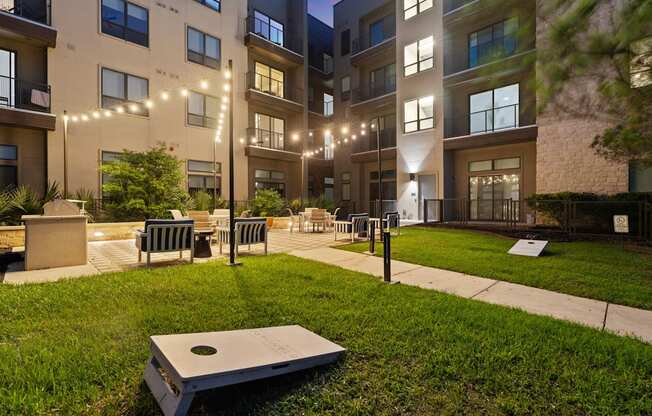 A modern apartment complex with a grassy courtyard and benches.