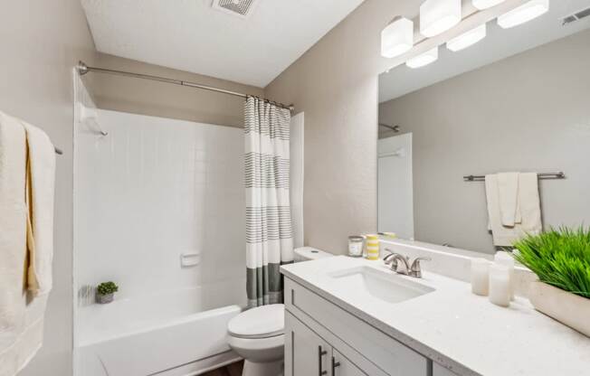 A white bathroom with a towel hanging on the wall.