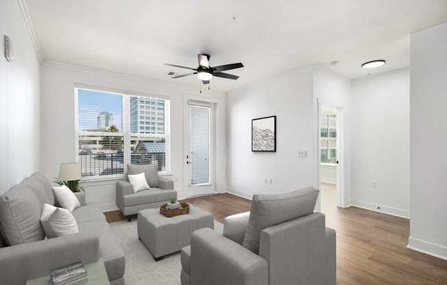 A living room with grey couches and a ceiling fan.