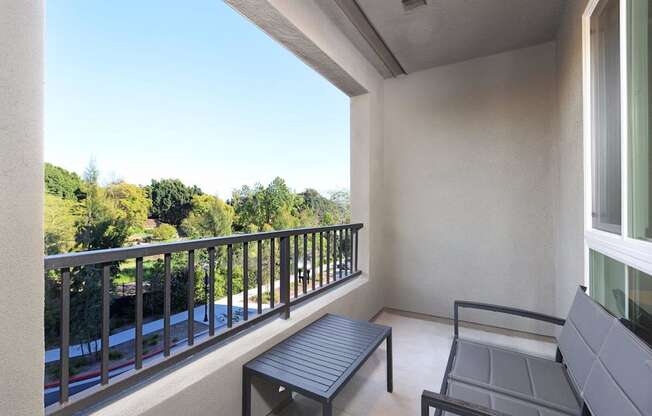 a balcony with a table and chairs and a view of trees