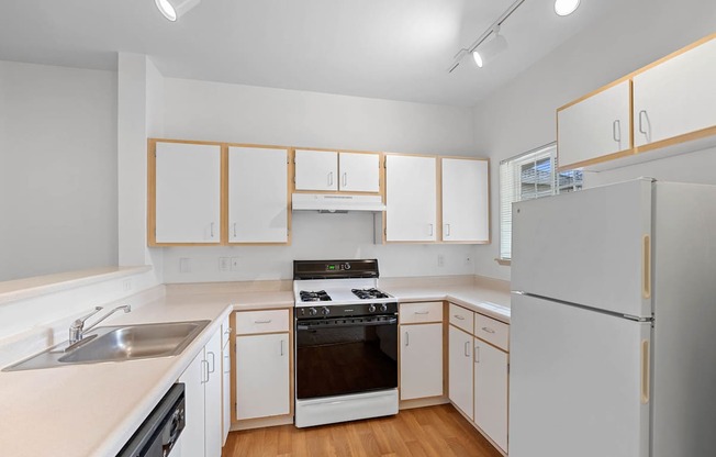 a kitchen with white cabinets and a stove and a refrigerator