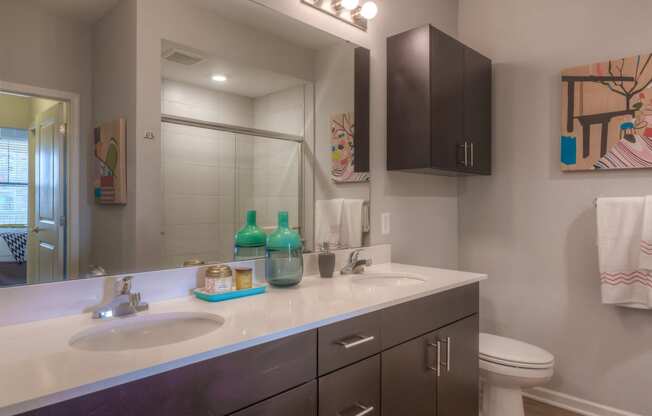 a bathroom with two sinks and a toilet