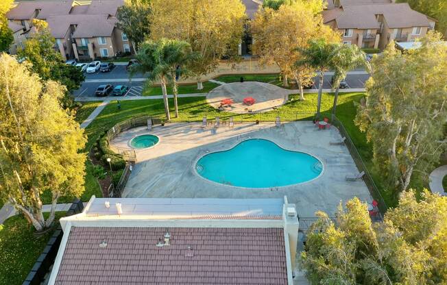 an aerial view of a backyard with a pool and hot tub