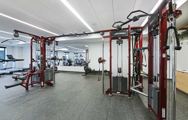 A gym with a variety of equipment including a weight bench and a leg press machine.