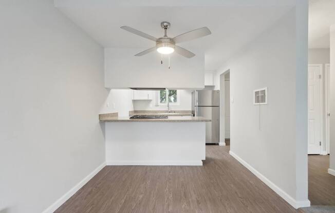A room with a ceiling fan and a counter.
