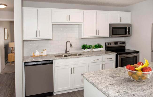 A kitchen with white cabinets and a black stove top oven.at Prosper West, Waite Park