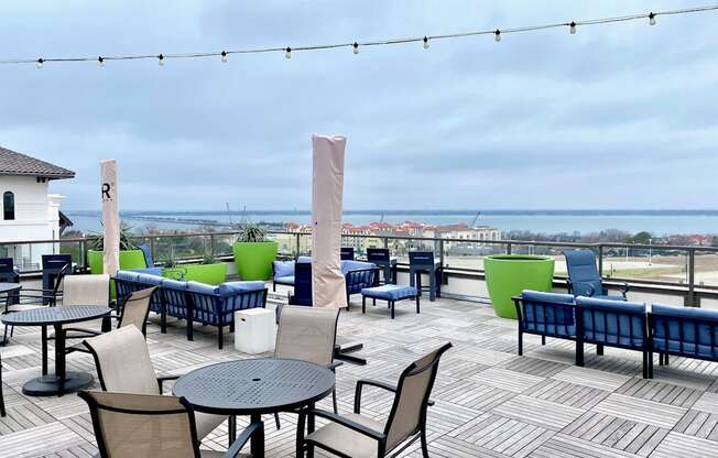 a deck with tables and chairs and a view of the ocean