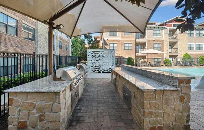 A stone wall with a metal railing and a white umbrella.