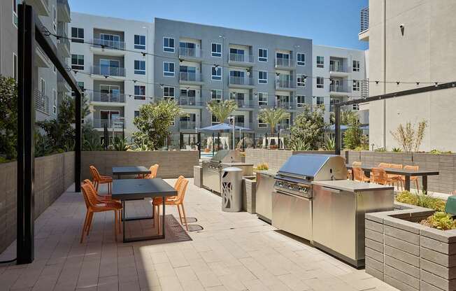 A patio with a table and chairs is surrounded by apartment buildings.