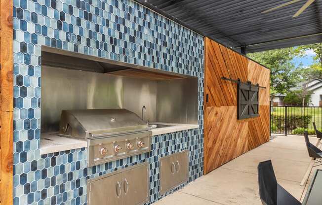 an outdoor kitchen with a grill and a wooden door