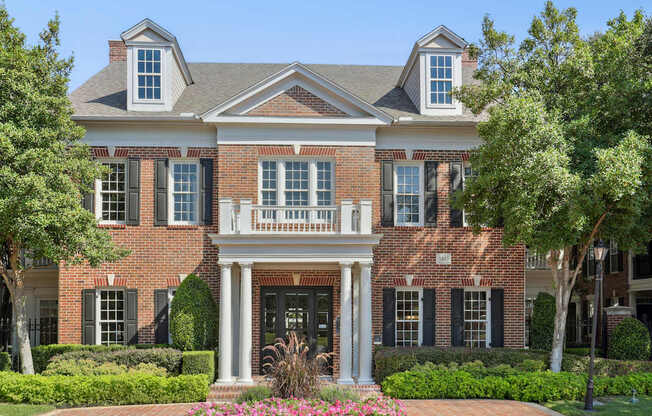 A large red brick house with a white porch.