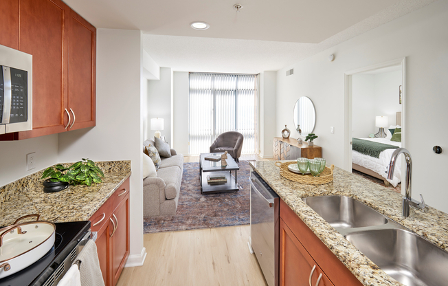 This open-concept view highlights the cohesive renovation, from the kitchen's stainless steel appliances and granite counters to the living area’s new vinyl plank wood-style flooring. Modern lighting and a Google NEST thermostat complete this sophisticated living space.