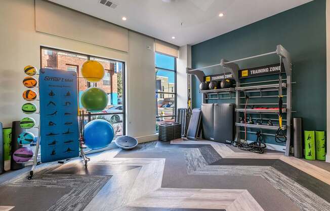 A gym with a variety of equipment including a blue exercise ball and a green exercise mat.