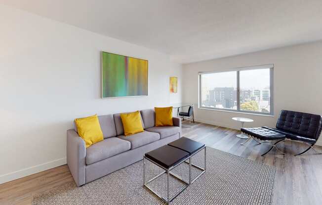 a living room with a gray couch and yellow pillows