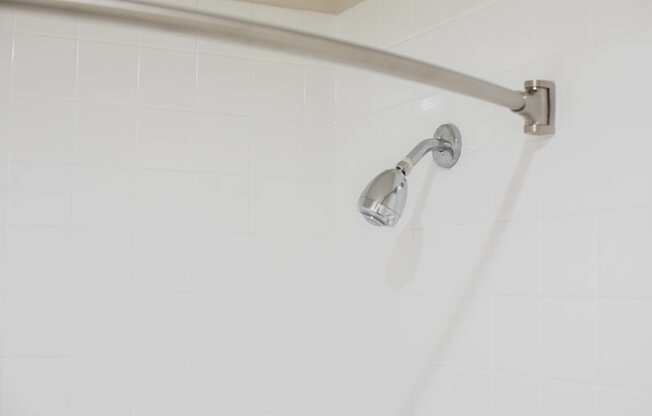 A shower head mounted on a white wall.