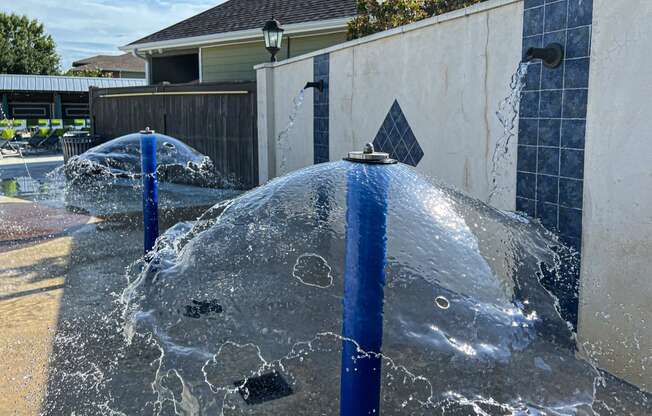 a fountain overflowing with water in front of a house