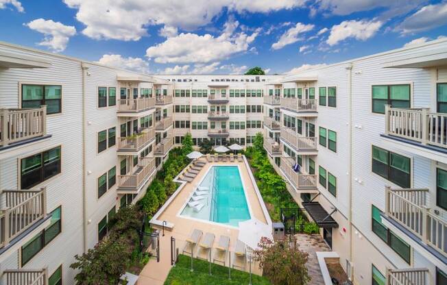 A swimming pool is surrounded by apartment buildings.