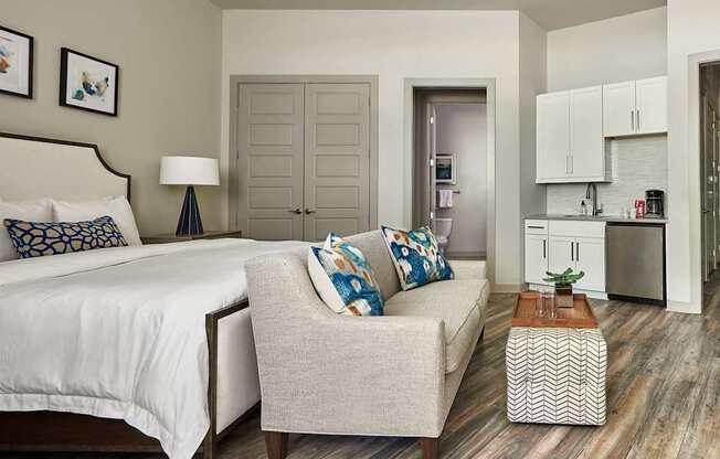 A bedroom with a bed, chair, and a small table.