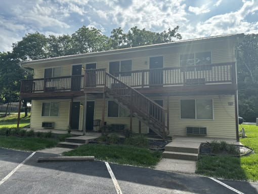 an apartment building with a deck and a staircase