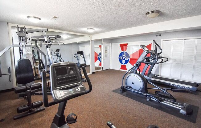 a gym with exercise machines and other equipment in a room with flags