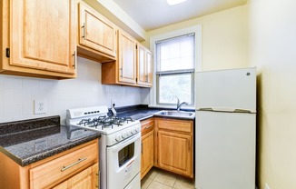 kitchen with gas range, wood cabinetry and energy efficient appliances at the foreland apartments in washinton dc