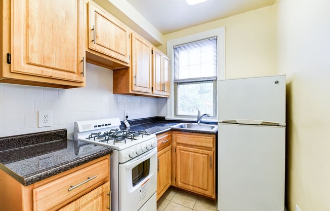 kitchen with gas range, wood cabinetry and energy efficient appliances at the foreland apartments in washinton dc