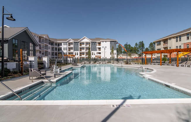 a swimming pool with an apartment building in the background