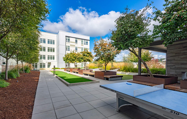 A ping pong table is in the middle of a courtyard.