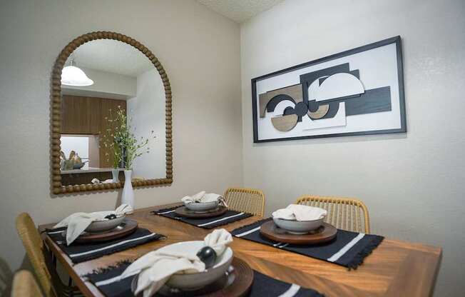 A dining room with a wooden table set for two.
