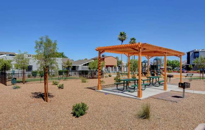 a picnic area with a picnic table and benches in a park