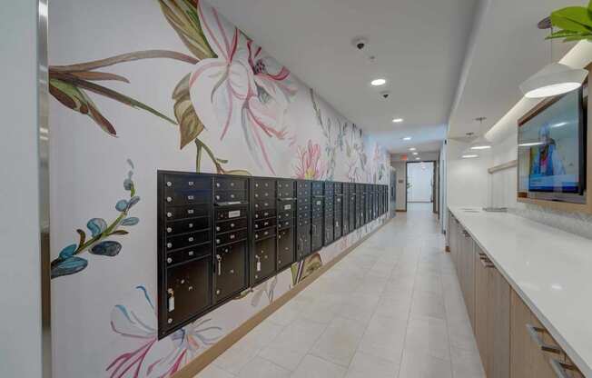 a long wall of mailboxes in a hallway with a floral wallpaper