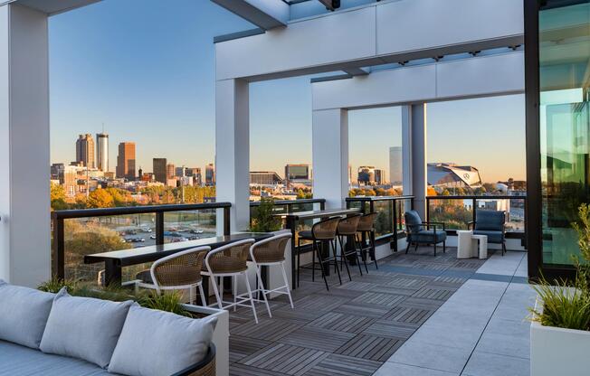 Rooftop seating framed by skyline views, with shaded lounge areas and bar-height tables designed for casual gatherings and quiet moments outdoors.