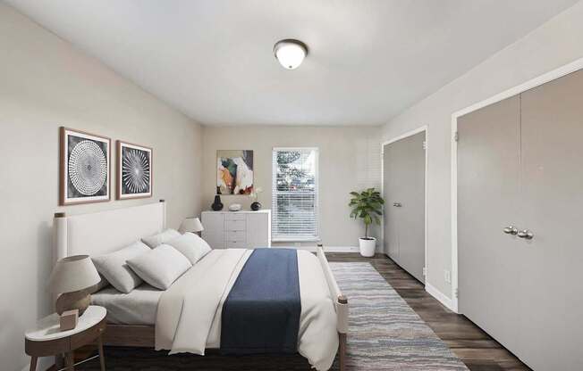 A bedroom with a bed, nightstand, and two framed pictures on the wall.