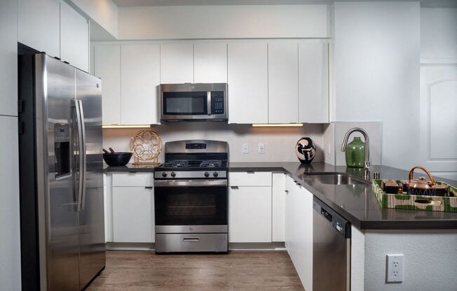 A modern kitchen with stainless steel appliances and white cabinets.
