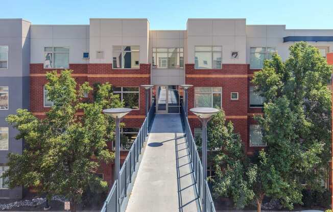 a bridge connects two buildings with trees in the middle