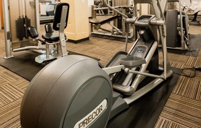 A Precor exercise bike is on a black mat in a gym at Addison on Fourth Apartments, Seattle, WA, 98104