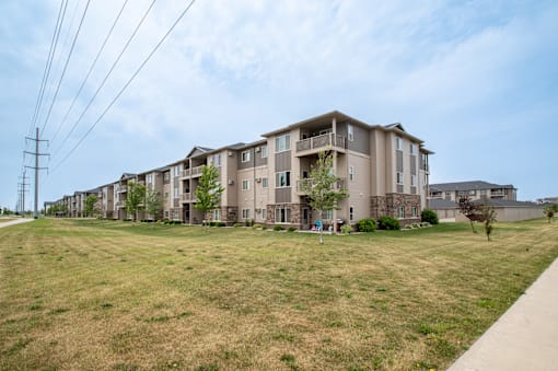 a large grassy area with an apartment building in the background