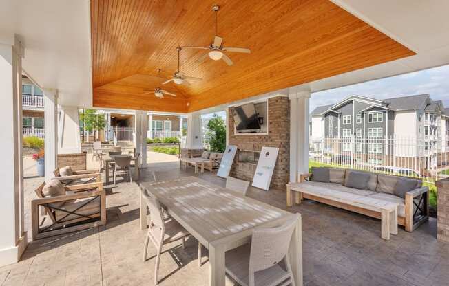 a patio with a wooden ceiling and a table with chairs