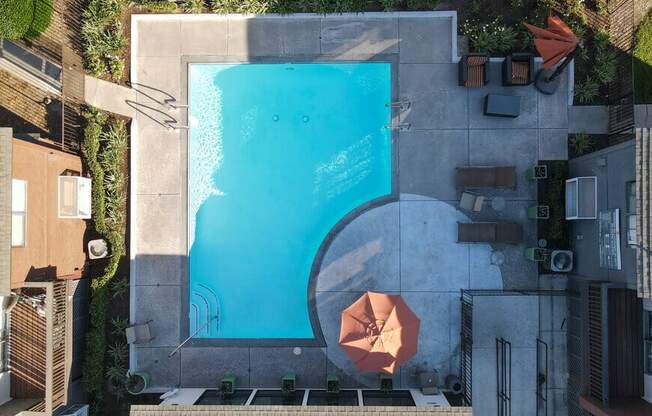 arial view of a pool in the middle of a building with umbrellas at Encore Apartments, Ontario, CA, 91764