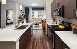 a kitchen with white counter tops and wooden floors