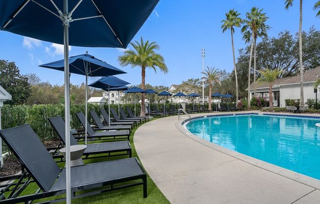 a swimming pool with lounge chairs and umbrellas at the resort