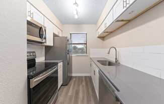 a kitchen with white cabinets and stainless steel appliances