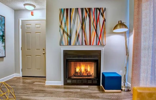 a living room with a fireplace and a painting on the wall