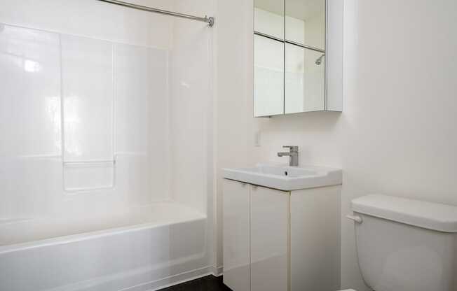 A white bathroom with a sink, toilet, and bathtub.