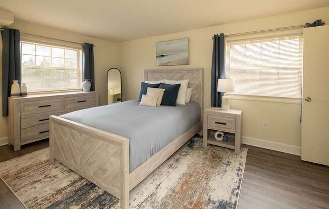 A bedroom with a large bed, nightstands, and a rug.