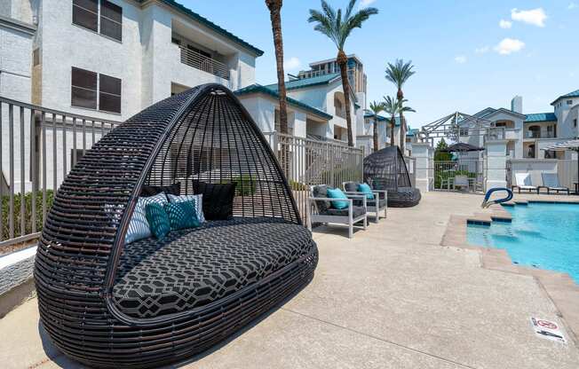 a swing chair next to a swimming pool