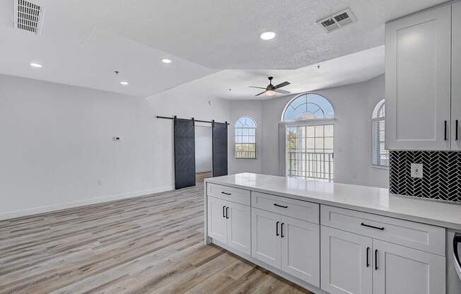 A kitchen with wooden floors and white cabinets.
